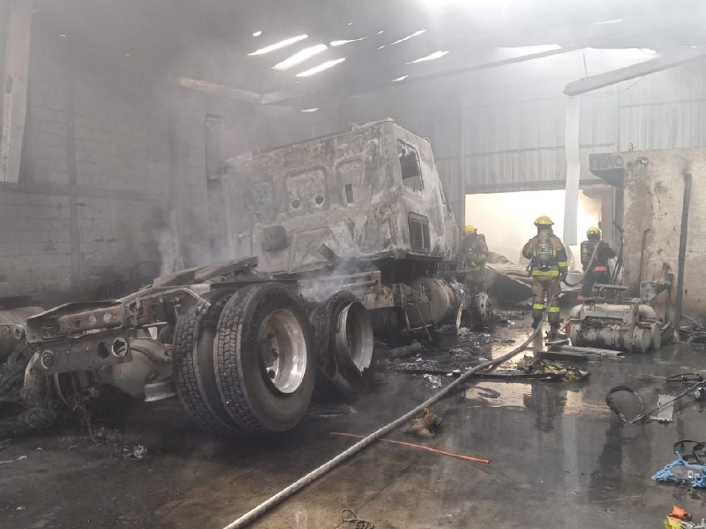 Incendio en taller mecánico de Jardines de Santiago consume tractocamión