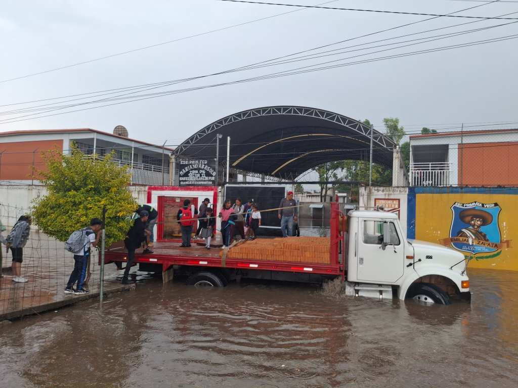 Fuertes lluvias dejan escuela primaria de Coronango bajo el agua; menores son evacuados en camiones de carga